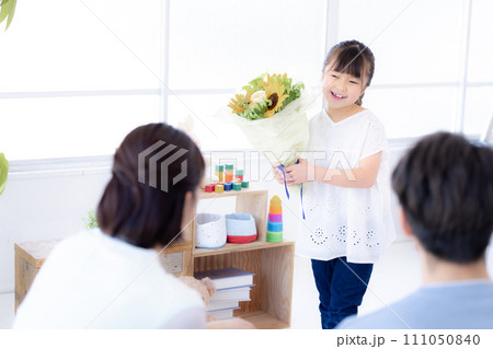 家族のポートレート　記念日に花束を渡す女の子 111050840