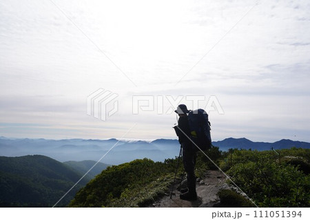 稜線から滝雲の彼方を眺める登山者 111051394