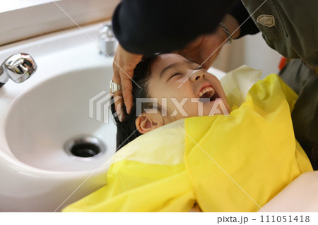 シャンプー台で髪を洗ってもらう女の子 111051418