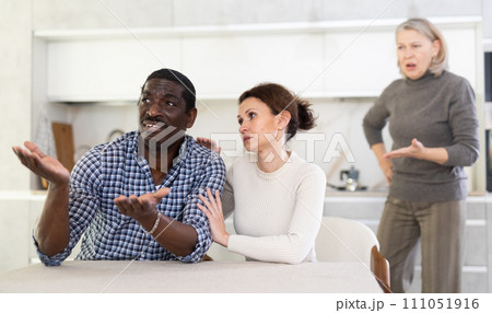 Wife calms husband down during quarrel with mother-in-law Wife calms husband down during quarrel with mother-in-law 111051916