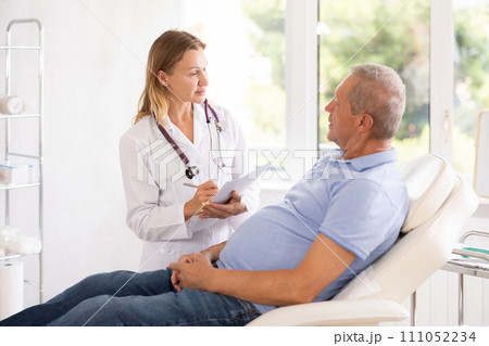 Adult woman doctor making notes in medical office 111052234