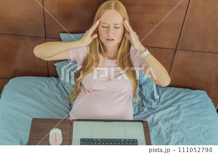Weary pregnant woman, tired of working from home, navigates the challenges of balancing professional tasks with pregnancy demands Weary pregnant woman, tired of working from home, navigates the challenges of balancing professional tasks with pregnancy demands 111052798