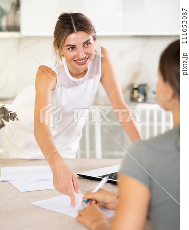 Middle-aged woman communicating with partner in the kitchen Middle-aged woman communicating with partner in the kitchen 111053087