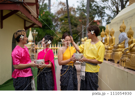 Young Thai people dress in traditional Thai costumes and play in the water during Songkran. 111054930