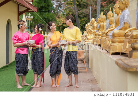 Young Thai people dress in traditional Thai costumes and play in the water during Songkran. 111054931