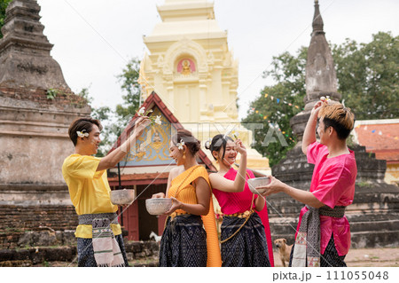 Young Thai people dress in traditional Thai costumes and play in the water during Songkran. Young Thai people dress in traditional Thai costumes and play in the water during Songkran. 111055048