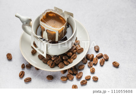 Drip coffee bag with ground coffee in cup Drip coffee bag with ground coffee in cup 111055608
