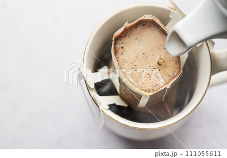 Drip coffee bag with ground coffee in cup Drip coffee bag with ground coffee in cup 111055611