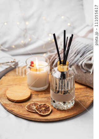 Home fragrance in glass bottle and bamboo sticks with scented candle,  paper book. 111055617