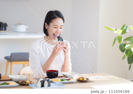 朝食　おにぎりを食べる女性 111056166