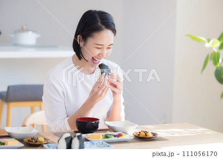 朝食　おにぎりを食べる女性 111056170