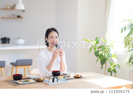 朝食 おにぎりを食べる女性 朝食 おにぎりを食べる女性 111056175