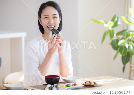 朝食　おにぎりを食べる女性 111056177