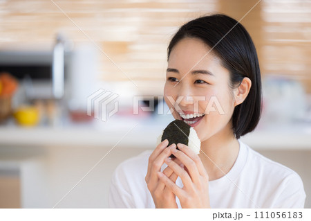 朝食　おにぎりを食べる女性 111056183