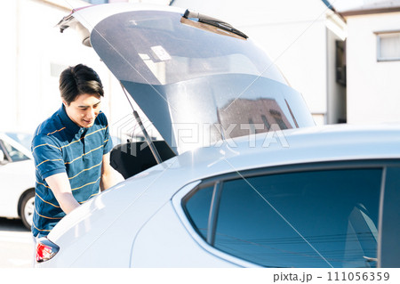 トランクを開ける若い男性 トランクを開ける若い男性 111056359