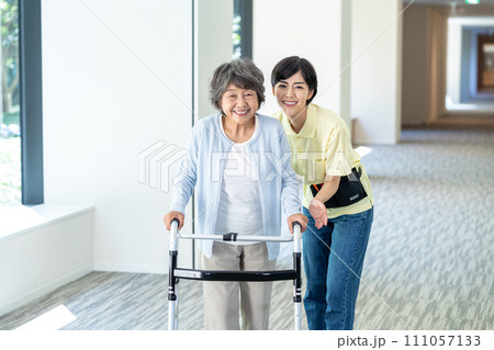 歩行器で歩くシニア女性と若いヘルパー　撮影協力「LINK FOREST」 111057133