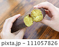 熱々の焼き芋を割る女性の手 111057826
