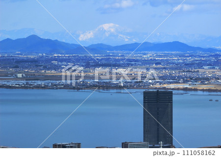 琵琶湖岸の高層ビルと遠方の雪山 琵琶湖岸の高層ビルと遠方の雪山 111058162