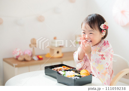 おせちを食べる1歳児 お正月 元旦 節の日 コピースペース おせちを食べる1歳児 お正月 元旦 節の日 コピースペース 111059238