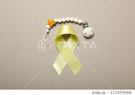Yellow satin ribbon with a wrist bracelet on a light background 111059466