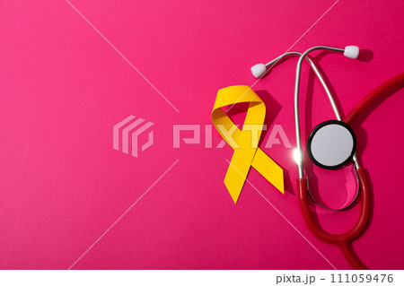 Red stethoscope with yellow ribbon on pink background 111059476