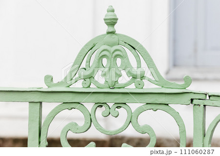 Decoration design elements of an outdoor vintage green forged railings Decoration design elements of an outdoor vintage green forged railings 111060287