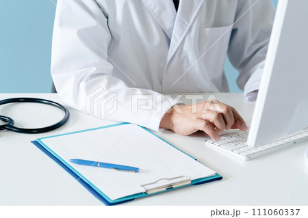 白衣の男性医師の手元 111060337