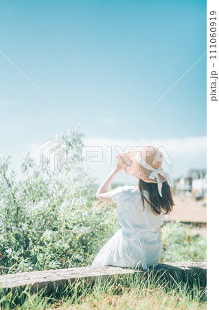 青空の下、草原に座る女性 青空の下、草原に座る女性 111060919