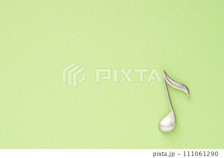 音楽イメージ 黄緑色の紙に置かれた8分音符のオブジェ 音楽イメージ 黄緑色の紙に置かれた8分音符のオブジェ 111061290