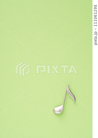 音楽イメージ 黄緑色の紙に置かれた8分音符のオブジェ 音楽イメージ 黄緑色の紙に置かれた8分音符のオブジェ 111061298