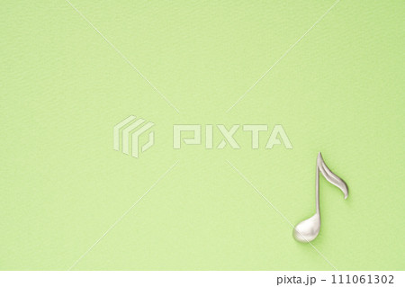 音楽イメージ 黄緑色の紙に置かれた8分音符のオブジェ 音楽イメージ 黄緑色の紙に置かれた8分音符のオブジェ 111061302
