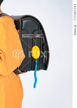 防犯ブザーをランドセルにつけた小学生 111061343
