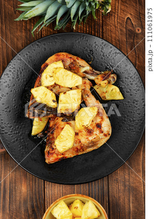 Barbecued chicken drumsticks and pineapple. 111061975