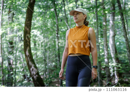 Fitness woman in sportswear walking through the woods Fitness woman in sportswear walking through the woods 111063116