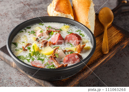 Zalewajka is a delicious traditional Polish sour rye soup with vegetables, sausage and dried mushrooms closeup on the plate. Horizontal Zalewajka is a delicious traditional Polish sour rye soup with vegetables, sausage and dried mushrooms closeup on the plate. Horizontal 111063268