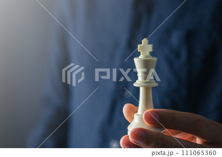 businessman hand holding white king of chess board ,team leader,  leadership and business strategy concept 111065360