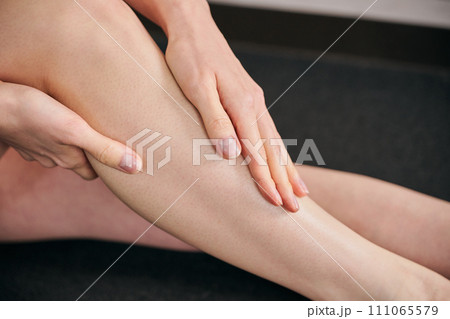 ふくらはぎをマッサージする30代女性 ふくらはぎをマッサージする30代女性 111065579