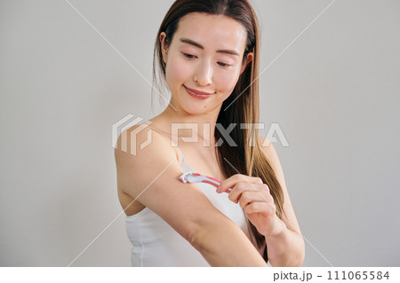女性用カミソリで腕毛を剃る30代女性 111065584