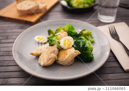 Pieces of fried chicken breast with boiled broccoli and quail eggs on plate for lunch Pieces of fried chicken breast with boiled broccoli and quail eggs on plate for lunch 111066065