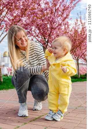 Baby's first steps with loving mother's help Baby's first steps with loving mother's help 111066740
