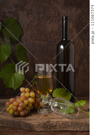 Still life with glass of white wine and grapes on vintage wooden background.. 111067374