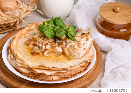 Homemade thin crepe (pancakes) with honey Homemade thin crepe (pancakes) with honey 111068795