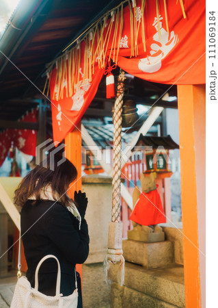 京都の伏見稲荷大社の朝のお参り 111069184