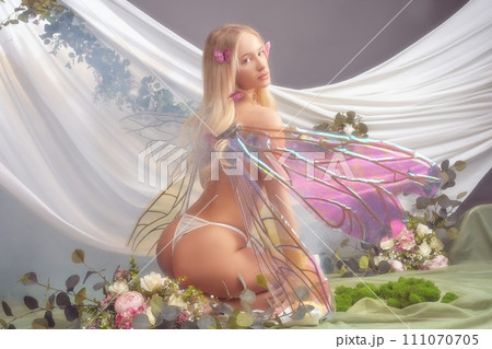 Cute female fairy caught sitting on flower meadow Cute female fairy caught sitting on flower meadow 111070705