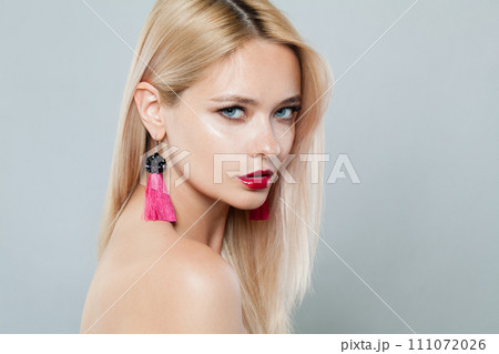 Perfect fashion model woman with blonde hair wears big pink color earrings. Fashionable lady 111072026