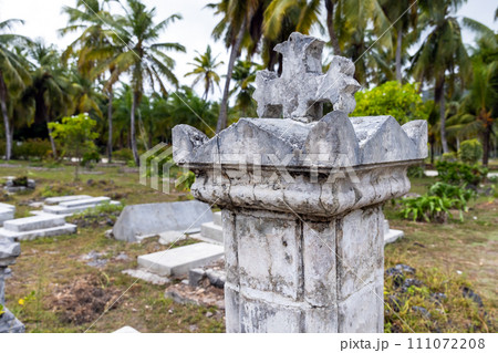 Gray gravestone with cross on top mounted at La Digue cemetery 111072208