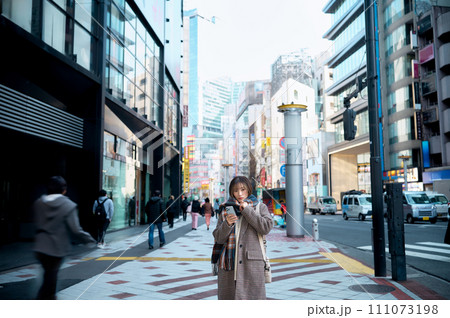 スマホ見る冬服の若い女性 スマホ見る冬服の若い女性 111073198