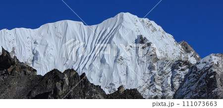 Blue sky over a high snow covered mountain in the Himalayas, view from Gorakshep, Nepal. Blue sky over a high snow covered mountain in the Himalayas, view from Gorakshep, Nepal. 111073663