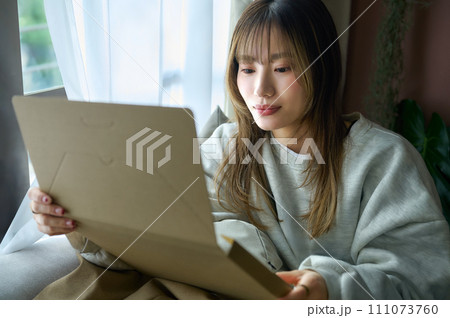荷物を確認する若い女性 荷物を確認する若い女性 111073760