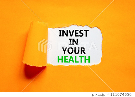 Invest in your health symbol. Concept word Invest in your health on beautiful white paper. Beautiful orange paper background. Invest in your health concept. Copy space. Invest in your health symbol. Concept word Invest in your health on beautiful white paper. Beautiful orange paper background. Invest in your health concept. Copy space. 111074656
